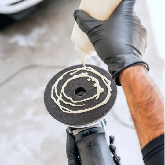 Applying polishing compound to a buffing pad