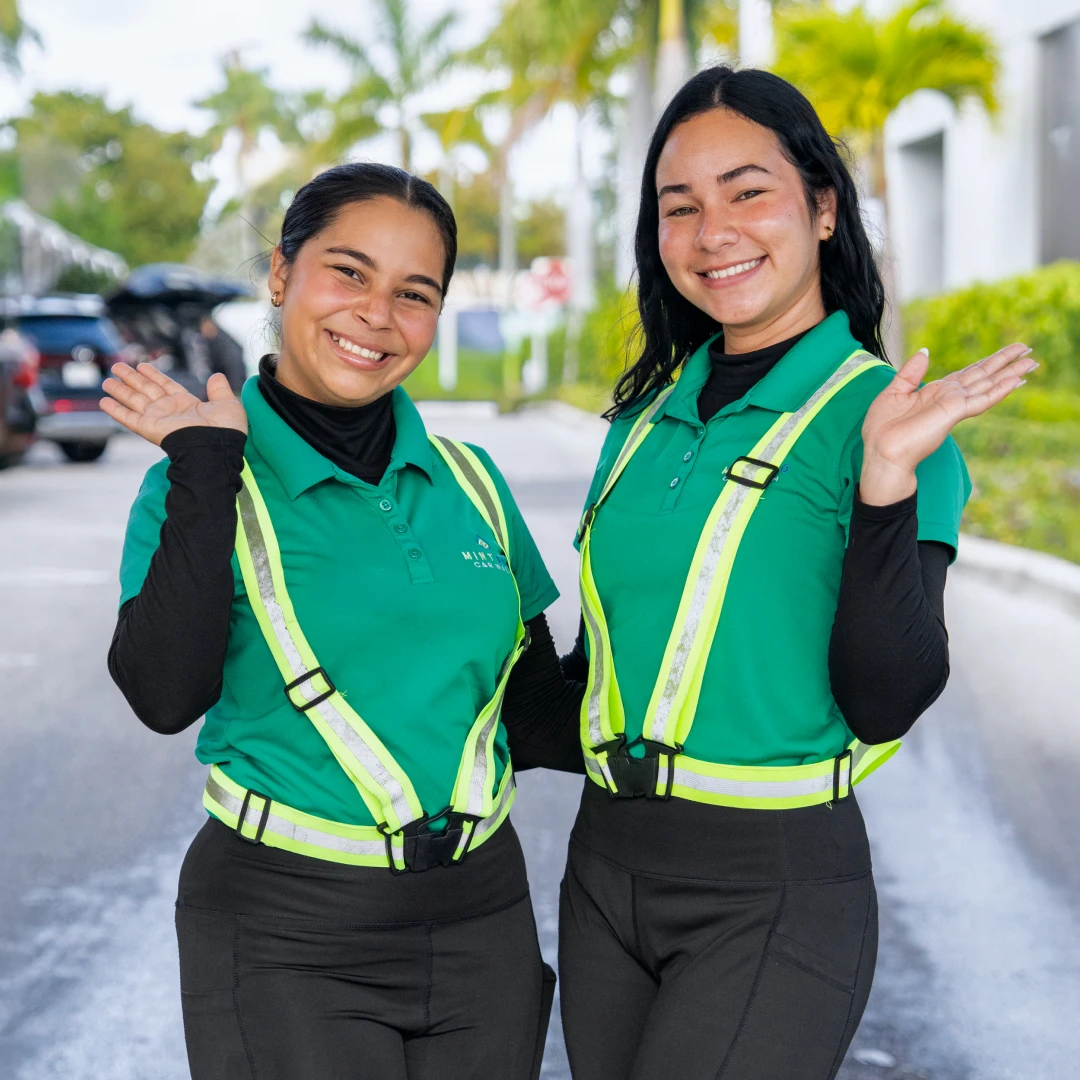 Two Mint Eco employees waving and smiling