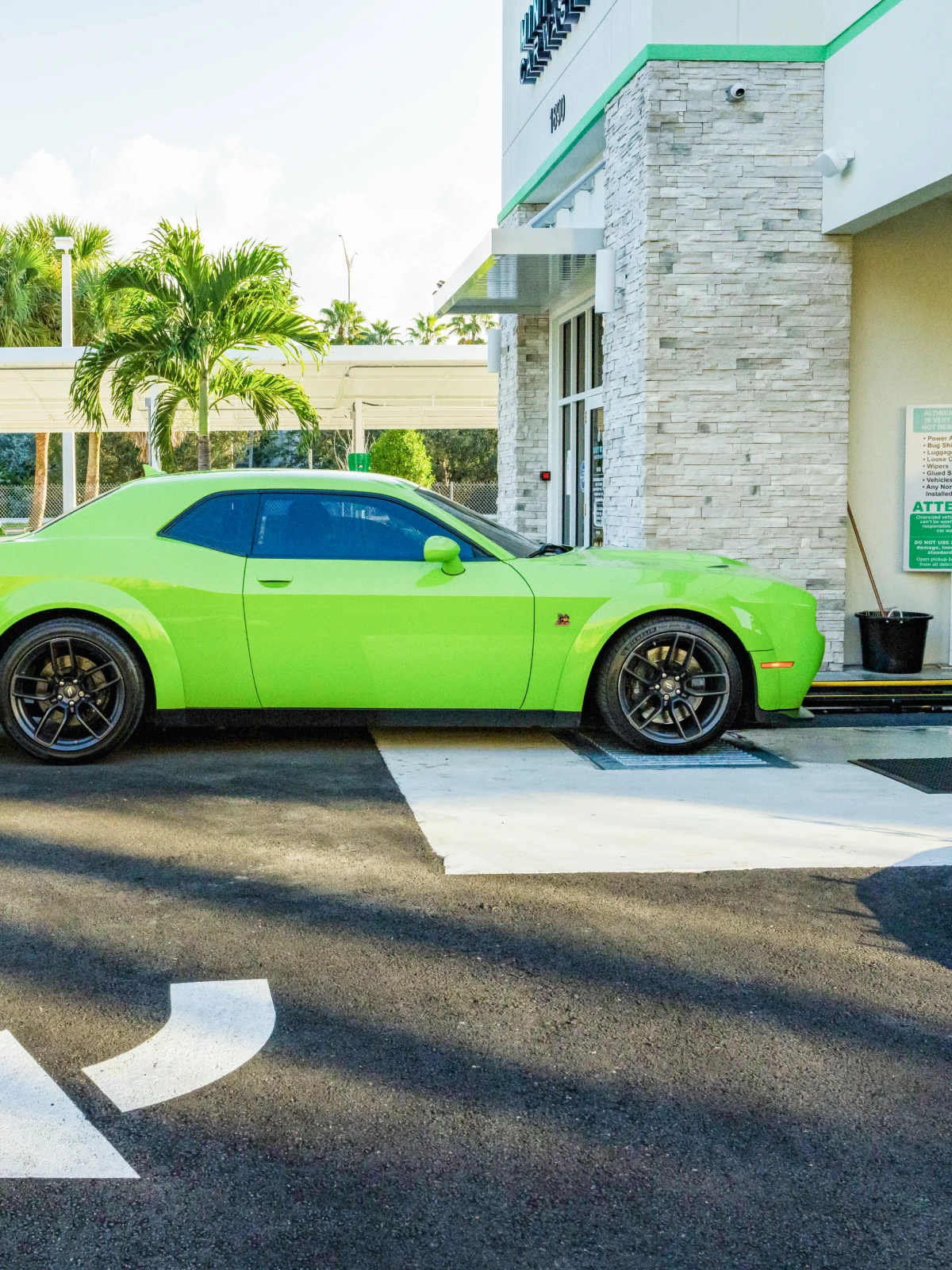 Green Dodge Challenger parked at the Mint Eco Car Wash Palm Beach Lakes entrance