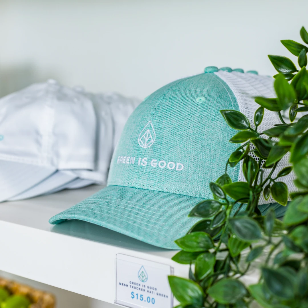 Green Is Good mesh trucker hats on a retail shelf