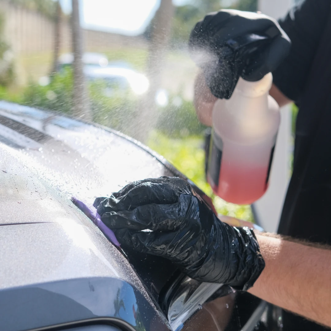 Cleaning a car window with an eco-friendly spray cleaner