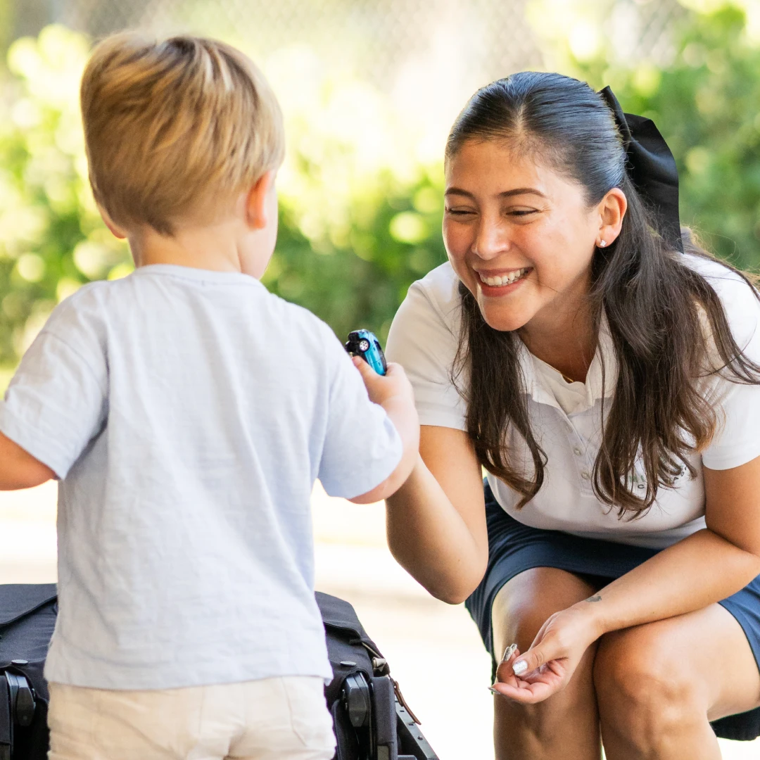Mint Eco employee giving a toy car to a young boy