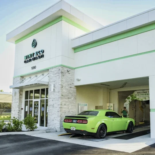 Mint Eco Car Wash Palm Beach Lakes location exterior with a green Dodge Challenger at the entrance