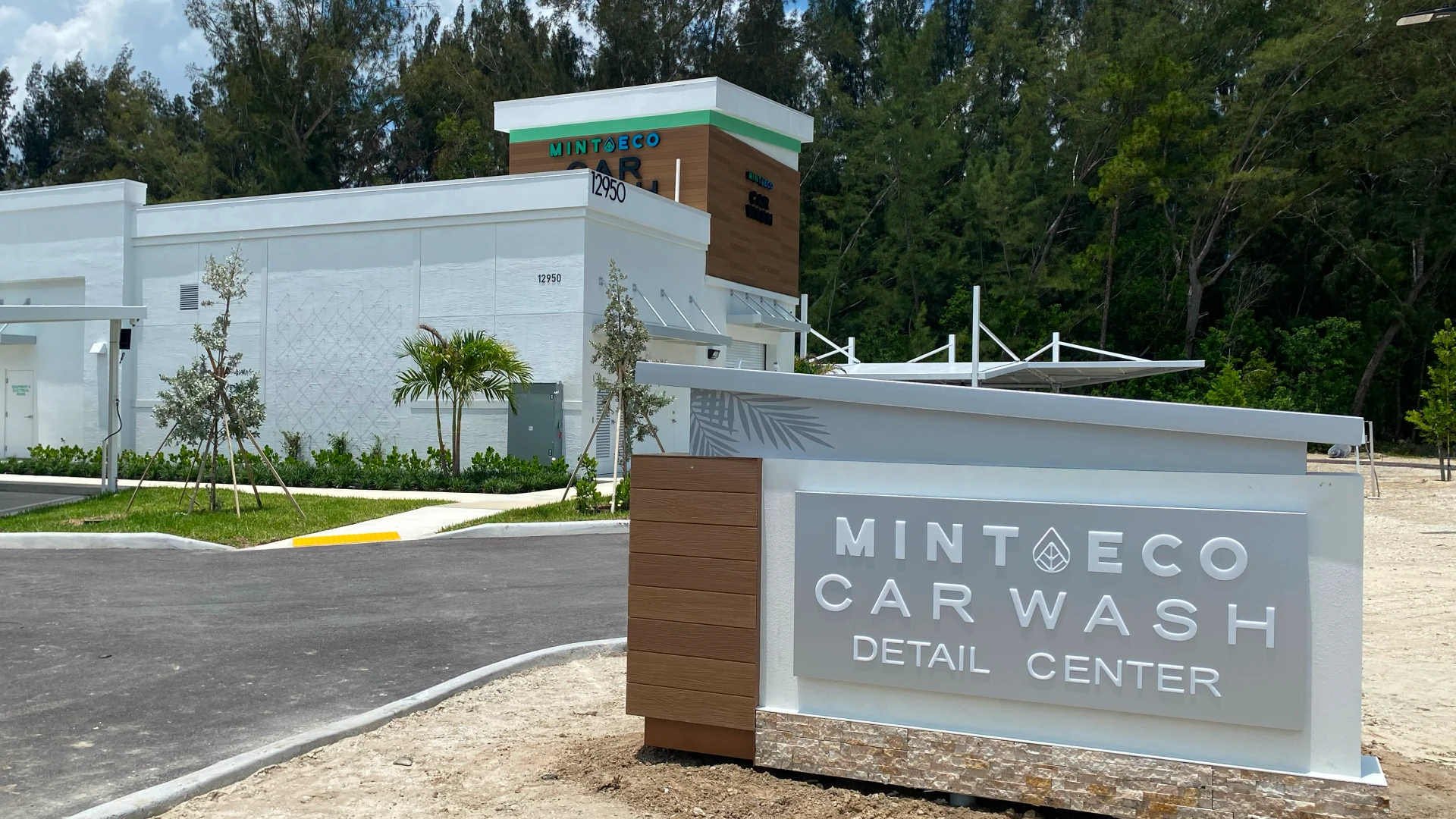 Aerial view of the Mint Eco Car Wash Detail Center building entrance with signage